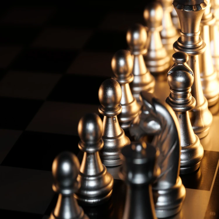 Silver chess pieces on a chessboard