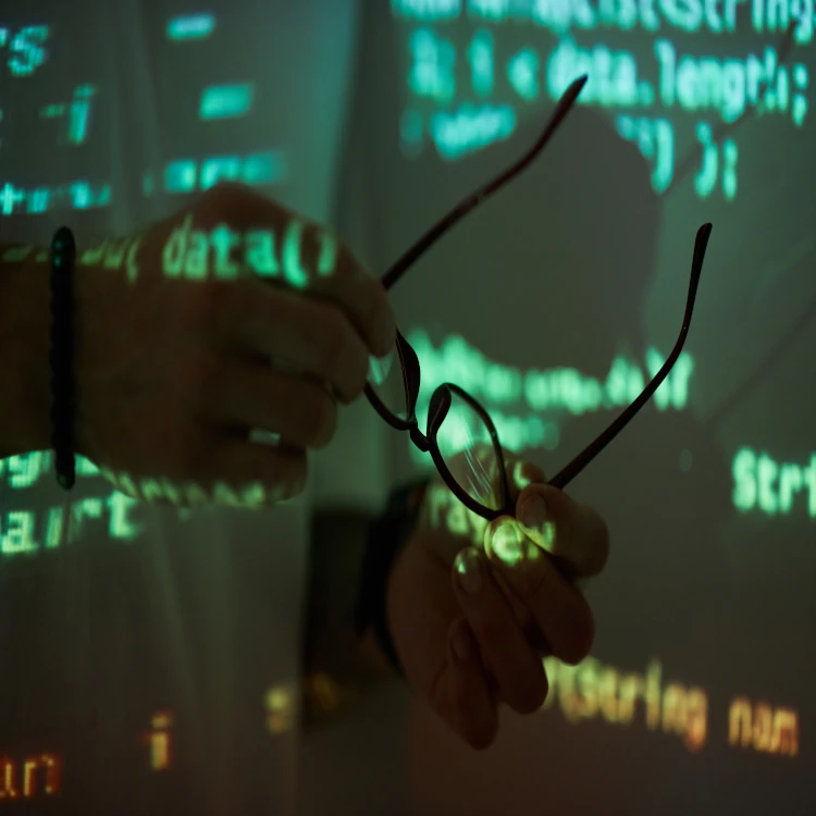 Code reflected over a person holding their glasses